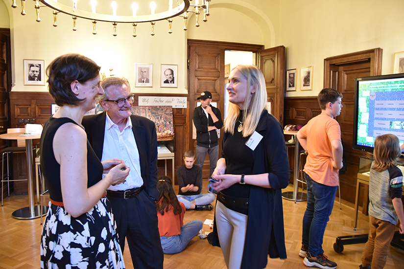Austausch mit Akademiepräsident Prof. Dr. Hans Wiesmeth kurz vor Beginn des Vortrags von Birgit Müller (rechts, Projekt Leipziger Ausgabe der Werke von Felix Mendelssohn Bartholdy), derweil im Hintergrund mit Knochen gewürfelt wird.